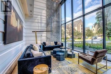 Toronto (Bay Street Corridor) condo for rent - A living room with a couch, chair, and a large window showing an outdoor view.