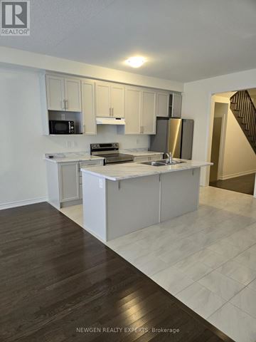 Brampton (Northwest Brampton) townhouse for rent - A kitchen with white cabinets and a wooden floor.