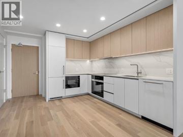 West Vancouver apartment for rent - A modern kitchen with wooden floors and white cabinetry.