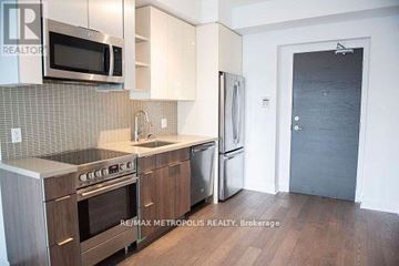 Toronto (Mimico) condo for rent - A kitchen with a stove top oven, microwave, and refrigerator.