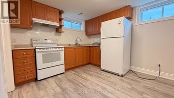 Pickering (Liverpool) apartment for rent - A kitchen with wooden cabinets and a white fridge.