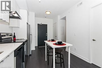 Burlington condo for rent - A modern kitchen with a dining table set for two.
