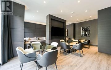 Toronto (Yonge-St. Clair) condo for rent - A modern living room with grey chairs and a television.