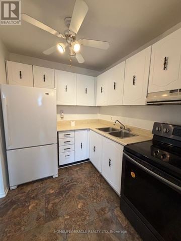 Kingston (West Of Sir John A. Blvd) townhouse for rent - A kitchen with white cabinets and a black stove top oven.