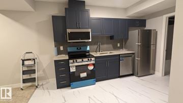 Edmonton apartment for rent - A kitchen with dark blue cabinets and stainless steel appliances.