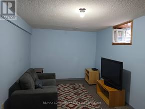 Toronto (Agincourt South-Malvern West) apartment for rent - A living room with a grey couch, a black television, and a patterned carpet.