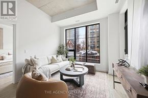 Ottawa condo for rent - A well-lit, modern living room with a large window and a view of a building outside.