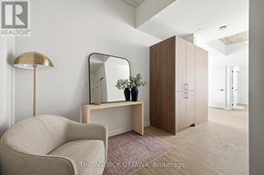 Ottawa condo for rent - A well-lit, modern bedroom with a chair, a mirror, and a cabinet.
