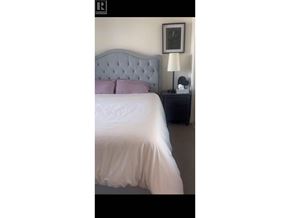 Burnaby apartment for rent - A bed with a white sheet and a grey headboard.