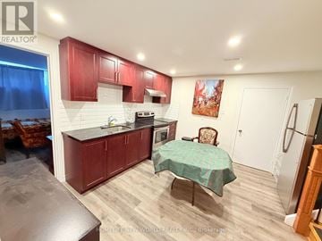 Toronto (Westminster-Branson) apartment for rent - A kitchen with red cabinets and a green tablecloth.
