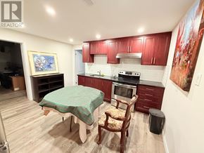 Toronto (Westminster-Branson) apartment for rent - A kitchen with red cabinets and a green tablecloth.