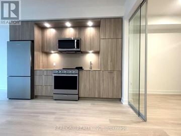 Toronto (Islington-City Centre West) condo for rent - A modern kitchen with wooden cabinets and stainless steel appliances.