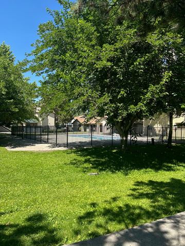 Reno apartment for rent - A green grass area with a tree and a fence.