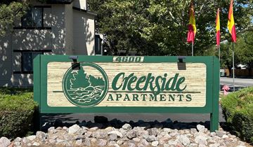 Reno apartment for rent - A sign for Creekside Apartments is displayed in front of a building.