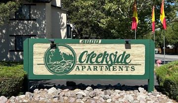 Reno apartment for rent - A sign for Creekside Apartments is displayed in front of a building.