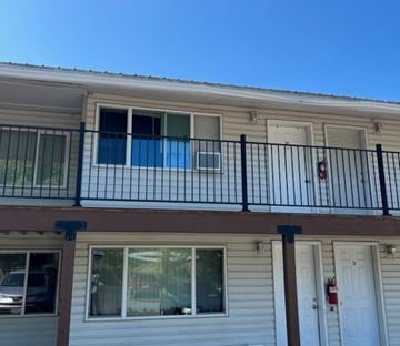 Whitefish apartment for rent - A balcony with a black railing and a red fire extinguisher on the wall.