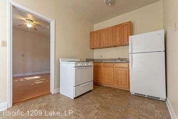 Los Angeles apartment for rent - A kitchen with a white refrigerator, white oven, and wooden cabinets.