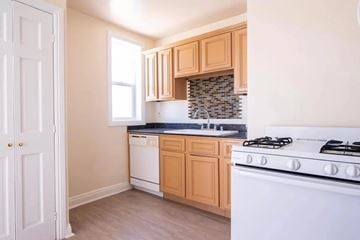 Los Angeles apartment for rent - A kitchen with a white stove and wooden cabinets.