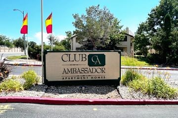 Reno apartment for rent - A sign for Club Ambassador Apartment Homes is displayed in front of a building.