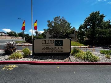 Reno apartment for rent - A sign for Club Ambassador Apartment Homes is displayed in front of a building.