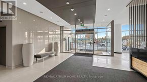 Toronto (Newtonbrook East) condo for rent - The lobby of a building with a glass wall and a bench.