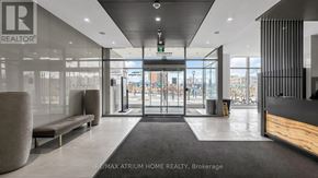 Toronto (Newtonbrook East) condo for rent - The lobby of a building with a large glass wall and a bench.