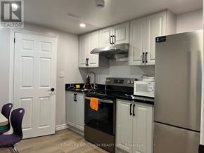 Toronto (Willowdale East) apartment for rent - A kitchen with white cabinets and a black stove top.
