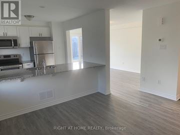 Ottawa townhouse for rent - A kitchen with a refrigerator, stove, and microwave.