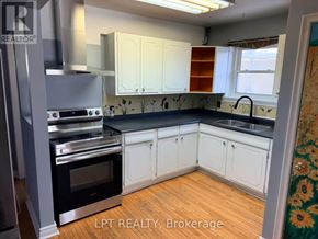 Richmond Hill (Crosby) apartment for rent - A kitchen with white cabinets and a black countertop.