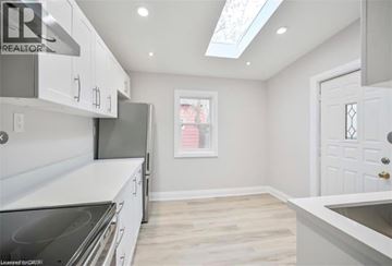 Hamilton apartment for rent - A kitchen with white cabinets and a stove top oven.