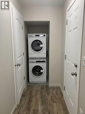 Maple Ridge apartment for rent - A small laundry room with a washer and dryer stacked on top of each other.