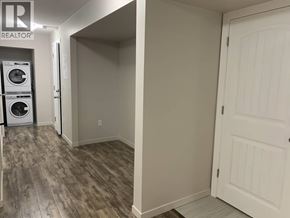 Maple Ridge apartment for rent - A laundry room with a washer and dryer stacked on top of each other.