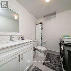 Markham (Rouge Fairways) apartment for rent - A white bathroom with a toilet, sink, and mirror.