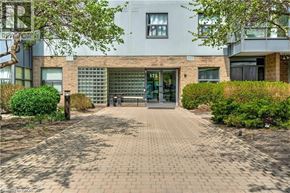 Hamilton condo for rent - A modern building with a glass entrance and a brick pathway leading to it.