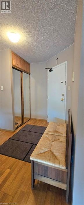 Hamilton condo for rent - A room with a wooden floor and a bench.