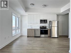 Kitchener townhouse for rent - A well-lit kitchen with a refrigerator, oven, and microwave.