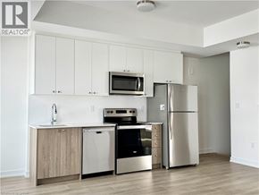 Kitchener townhouse for rent - A kitchen with white cabinets and stainless steel appliances.