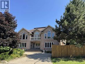Mississauga (Rathwood) apartment for rent - A large house with a driveway and a fence in front of it.