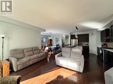 Ottawa townhouse for rent - A living room with a couch, chair, and a table with a lamp.