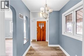 Kitchener apartment for rent - A hallway with a wooden door and a chandelier.