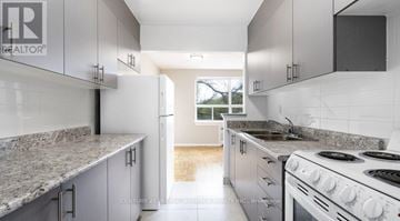 Toronto (Stonegate-Queensway) condo for rent - A kitchen with granite countertops and white cabinets.