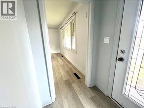Hamilton apartment for rent - A hallway with a white door and a window with white trim.