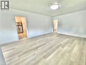 Hamilton apartment for rent - A room with wooden flooring and two open doors.