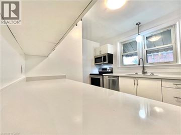 Hamilton apartment for rent - A white kitchen with a microwave and oven built into the cabinetry.
