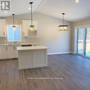 South Stormont apartment for rent - A well-lit kitchen with white cabinets and a wooden floor.