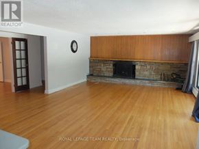 Ottawa multi-family for rent - A living room with a fireplace and wooden floors.