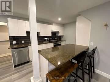 Ottawa multi-family for rent - A kitchen with a granite countertop and stainless steel appliances.