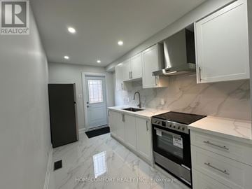 Toronto (Weston-Pellam Park) duplex for rent - A modern kitchen with white cabinets and marble countertops.