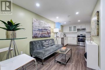 Pickering (Village East) apartment for rent - A living room with a grey couch and a glass table with a plant on it.