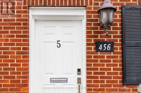 Ottawa apartment for rent - A white door with the number 5 on it is on a red brick wall.